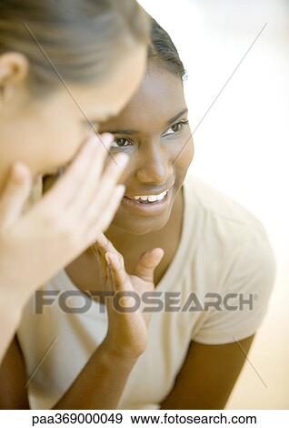Stock Photo - Two teen girls whispering. Fotosearch
