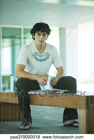 Male college student sitting on bench, studying View Large Photo Image Stock Photo - Male college student sitting on bench, studying. Fotosearch