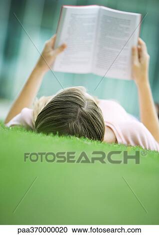 Teenage girl lying in grass, reading book View Large Photo Image Stock Image - Teenage girl lying in grass, reading book. Fotosearch
