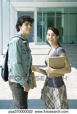 Stock Image - Two college students standing, smiling. Fotosearch