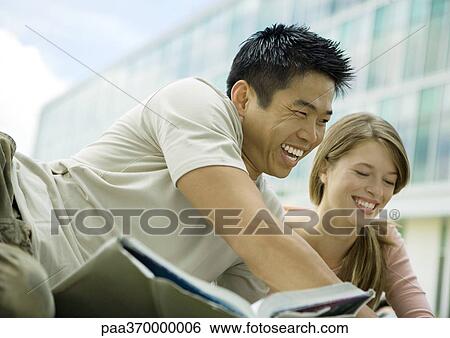 Stock Photograph - Two college students studying and laughing. Fotosearch