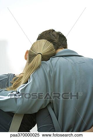 Stock Photography - Young couple, woman's head on man's shoulder, rear view. Fotosearch