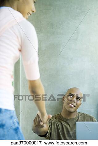 Young woman reaching hand out to man View Large Photo Image Stock Photo - Young woman reaching hand out to man. Fotosearch