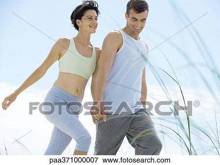 Stock Photo - Couple walking in exercise clothes. Fotosearch