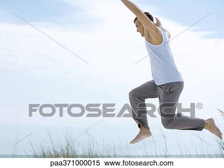Man jumping in coastal setting View Large Photo Image Stock Photography - Man jumping in coastal setting. Fotosearch