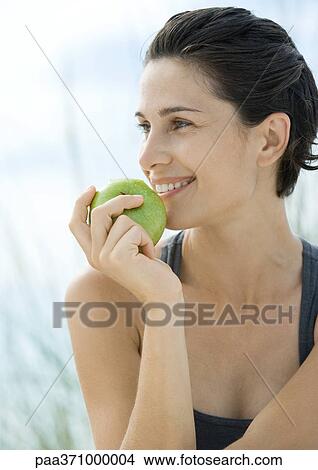 Woman holding up apple View Large Photo Image Picture - Woman holding up apple. Fotosearch
