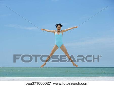 Woman jumping on beach View Large Photo Image Stock Photo - Woman jumping on beach. Fotosearch