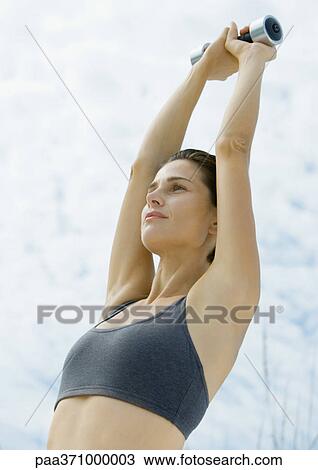Woman lifting dumbell over head View Large Photo Image Stock Image - Woman lifting dumbell over head. Fotosearch