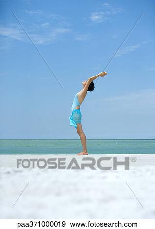Woman performing sun salutation on beach View Large Photo Image Stock Photo - Woman performing sun salutation on beach. Fotosearch