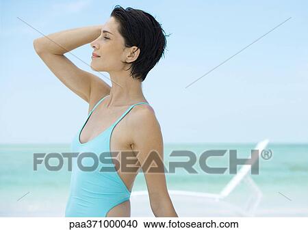 Woman standing on beach in front of lounge chair, profile View Large Photo Image Stock Image - Woman standing on beach in front of lounge chair, profile. Fotosearch