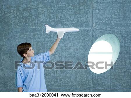 Boy holding up toy airplane View Large Photo Image Stock Image - Boy holding up toy airplane. Fotosearch