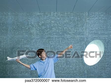 Stock Photo - Boy holding up toy plane and pointing to distance. Fotosearch