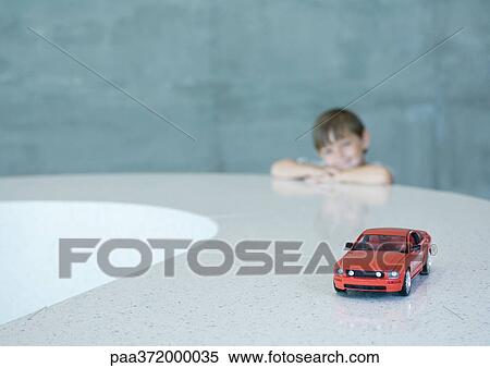 Boy looking longingly at toy sports car View Large Photo Image Stock Photography - Boy looking longingly at toy sports car. Fotosearch