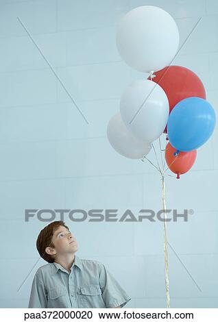 Boy looking up at bunch of balloons View Large Photo Image Stock Image - Boy looking up at bunch of balloons. Fotosearch
