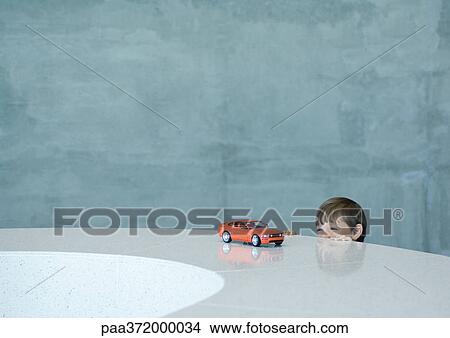 Boy peeking at toy sports car View Large Photo Image Picture - Boy peeking at toy sports car. Fotosearch