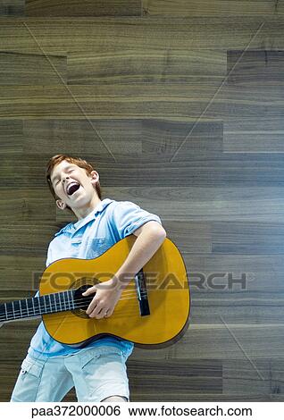 Boy playing guitar and singing with emotion View Large Photo Image Stock Photograph - Boy playing guitar and singing with emotion. Fotosearch