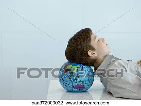 Boy resting head on globe View Large Photo Image Stock Image - Boy resting head on globe. Fotosearch