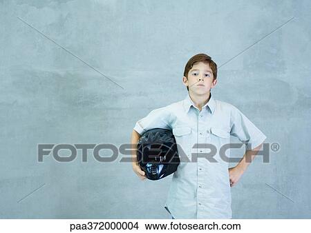 Picture - Boy standing with helmet under arm. Fotosearch