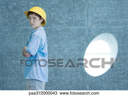 Stock Image - Boy wearing hard hat. Fotosearch