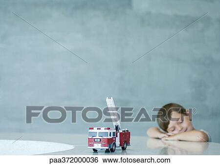 Boy with eyes closed, toy fire engine in foreground View Large Photo Image Stock Photograph - Boy with eyes closed, toy fire engine in foreground. Fotosearch
