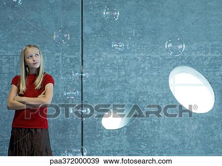 Girl watching bubbles float in the air View Large Photo Image Stock Photo - Girl watching bubbles float in the air. Fotosearch