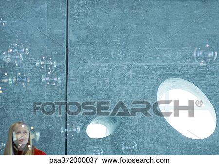 Girl watching bubbles floating in the air View Large Photo Image Stock Photo - Girl watching bubbles floating in the air. Fotosearch