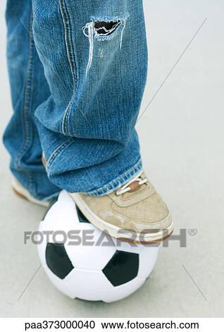 Boy resting foot on soccer ball, close-up View Large Photo Image Stock Image - Boy resting foot on soccer ball, close-up. Fotosearch