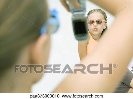 Girl taking photo of friend with cell phone View Large Photo Image Stock Image - Girl taking photo of friend with cell phone. Fotosearch