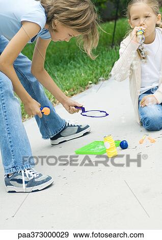 Girls blowing bubbles View Large Photo Image Stock Photo - Girls blowing bubbles. Fotosearch