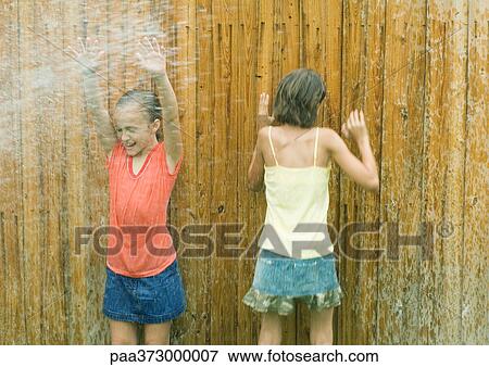 Girls standing in spray getting wet View Large Photo Image Stock Photo - Girls standing in spray getting wet. Fotosearch