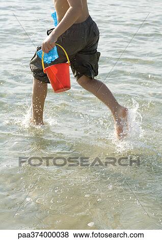 Boy running in surf at beach View Large Photo Image Stock Photo - Boy running in surf at beach. Fotosearch