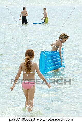 Children playing in water at the beach View Large Photo Image Stock Image - Children playing in water at the beach. Fotosearch