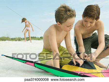 Stock Photo - Children playing with kite on the beach. Fotosearch