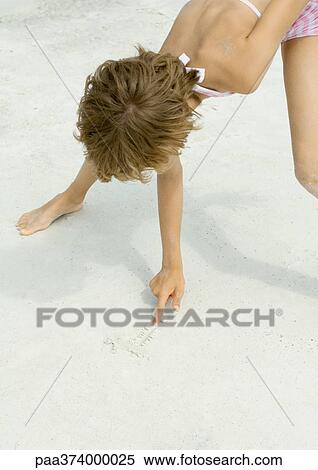 Stock Photography - Girl drawing in sand. Fotosearch