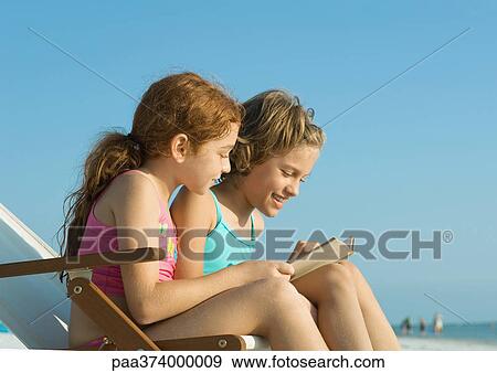 Two girls reading on beach View Large Photo Image Stock Photo - Two girls reading on beach. Fotosearch
