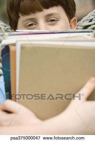 Stock Photo - Boy holding stack of school books. Fotosearch