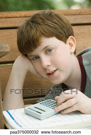 Stock Image - Boy with calculator and school book. Fotosearch
