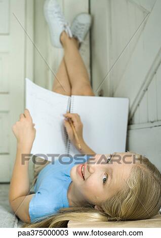 Girl doing homework with legs up View Large Photo Image Stock Image - Girl doing homework with legs up. Fotosearch