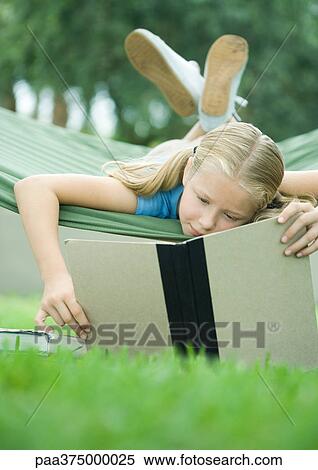 Girl lying in hammock reading book View Large Photo Image Stock Photography - Girl lying in hammock reading book. Fotosearch