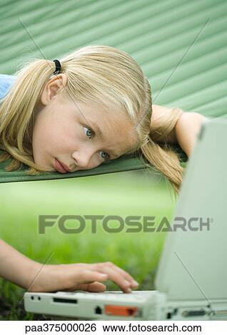 Girl lying in hammock using laptop View Large Photo Image Stock Photograph - Girl lying in hammock using laptop. Fotosearch