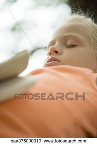 Girl sleeping with book on stomach View Large Photo Image Stock Photo - Girl sleeping with book on stomach. Fotosearch