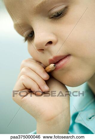 Girl thinking, holding pencil next to mouth View Large Photo Image Stock Photograph - Girl thinking, holding pencil next to mouth. Fotosearch