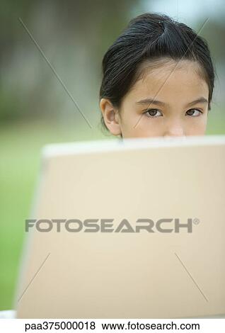 Girl's face, partially obscured by foreground View Large Photo Image Stock Photo - Girl's face, partially obscured by foreground. Fotosearch