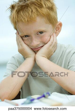 Picture - Little boy holding head, smiling. Fotosearch