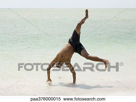 Man doing cartwheel in surf View Large Photo Image Stock Photography - Man doing cartwheel in surf. Fotosearch