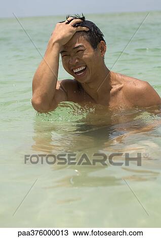 Stock Image - Man in sea, laughing. Fotosearch