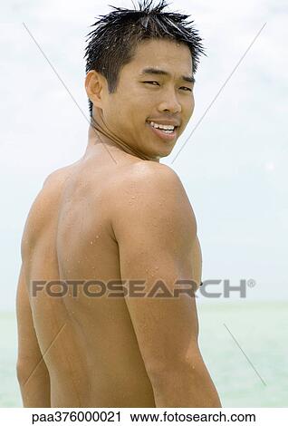 Man looking over shoulder, sea in background View Large Photo Image Stock Image - Man looking over shoulder, sea in background. Fotosearch