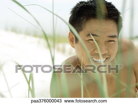 Man lying in dune grass on beach View Large Photo Image Stock Image - Man lying in dune grass on beach. Fotosearch
