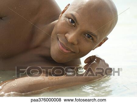 Man lying in shallow water View Large Photo Image Stock Photo - Man lying in shallow water. Fotosearch