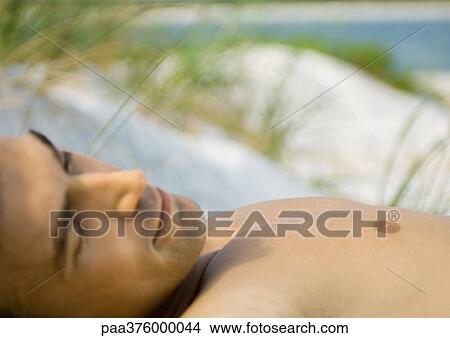 Man lying on beach View Large Photo Image Picture - Man lying on beach. Fotosearch